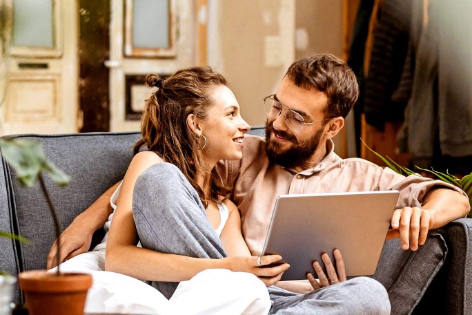 Paar entspannt sich mit einem Laptop in Innenräumen